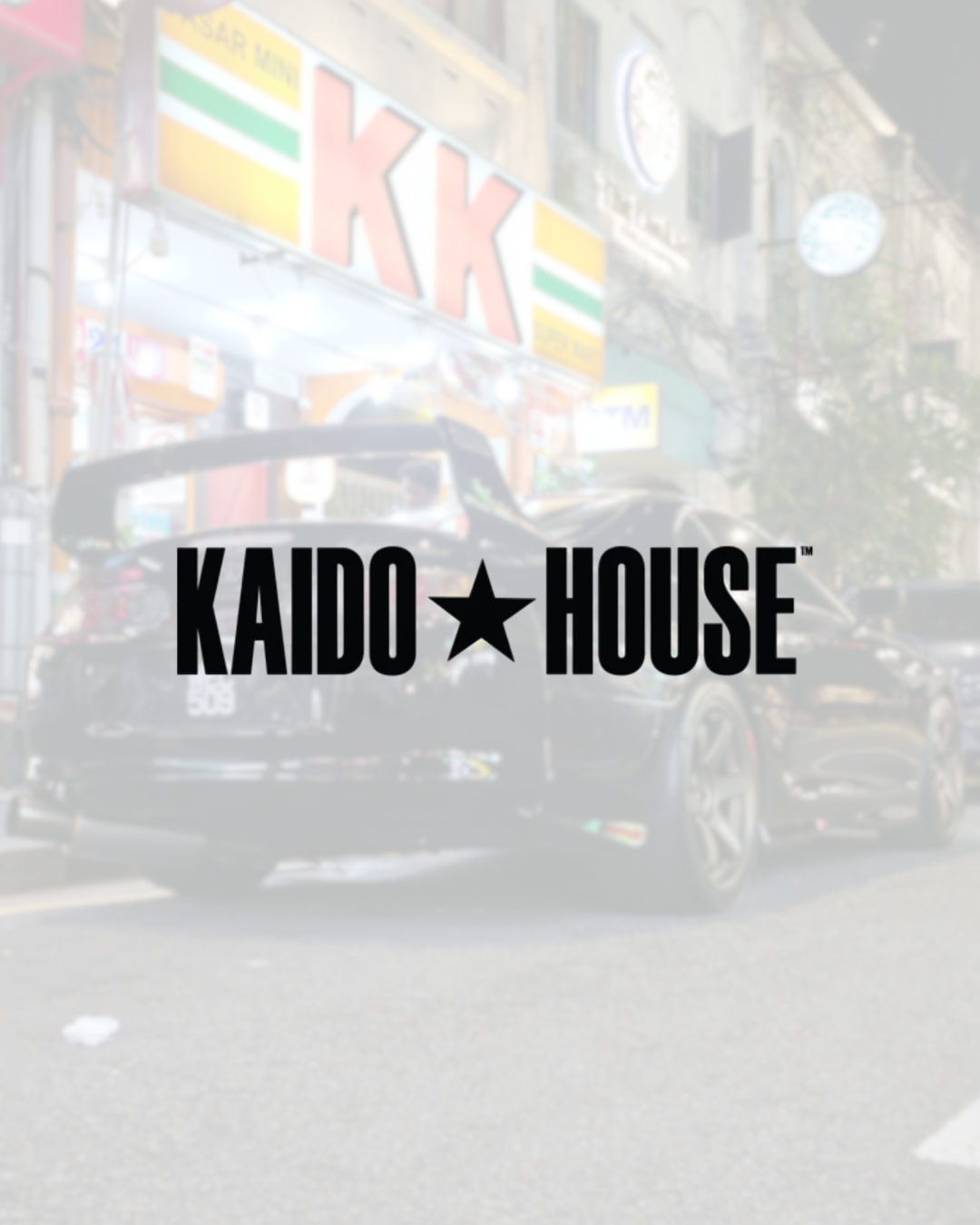 Kaido House logo overlay on a street scene with a black sports car and urban buildings