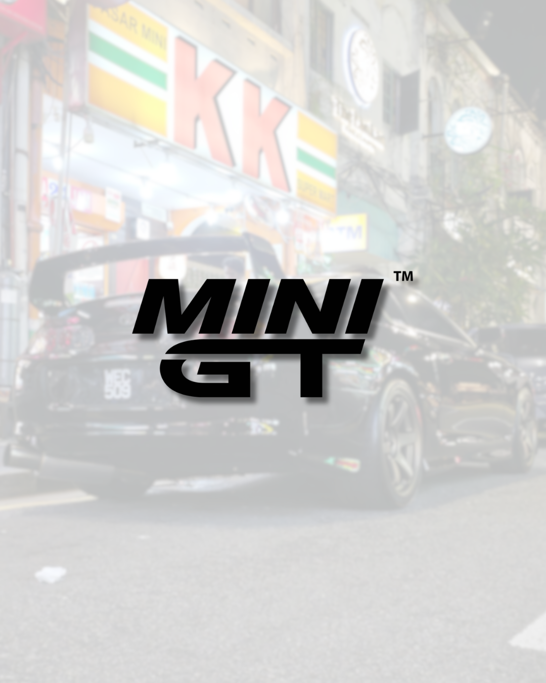 MINI GT collection logo overlay on a street background with a black sports car at night