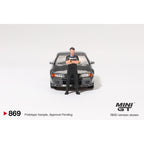*EN CAMINO* Mini GT Nissan Skyline GT-R (R32) Gunmetal W/ Matsuda Figure - 869